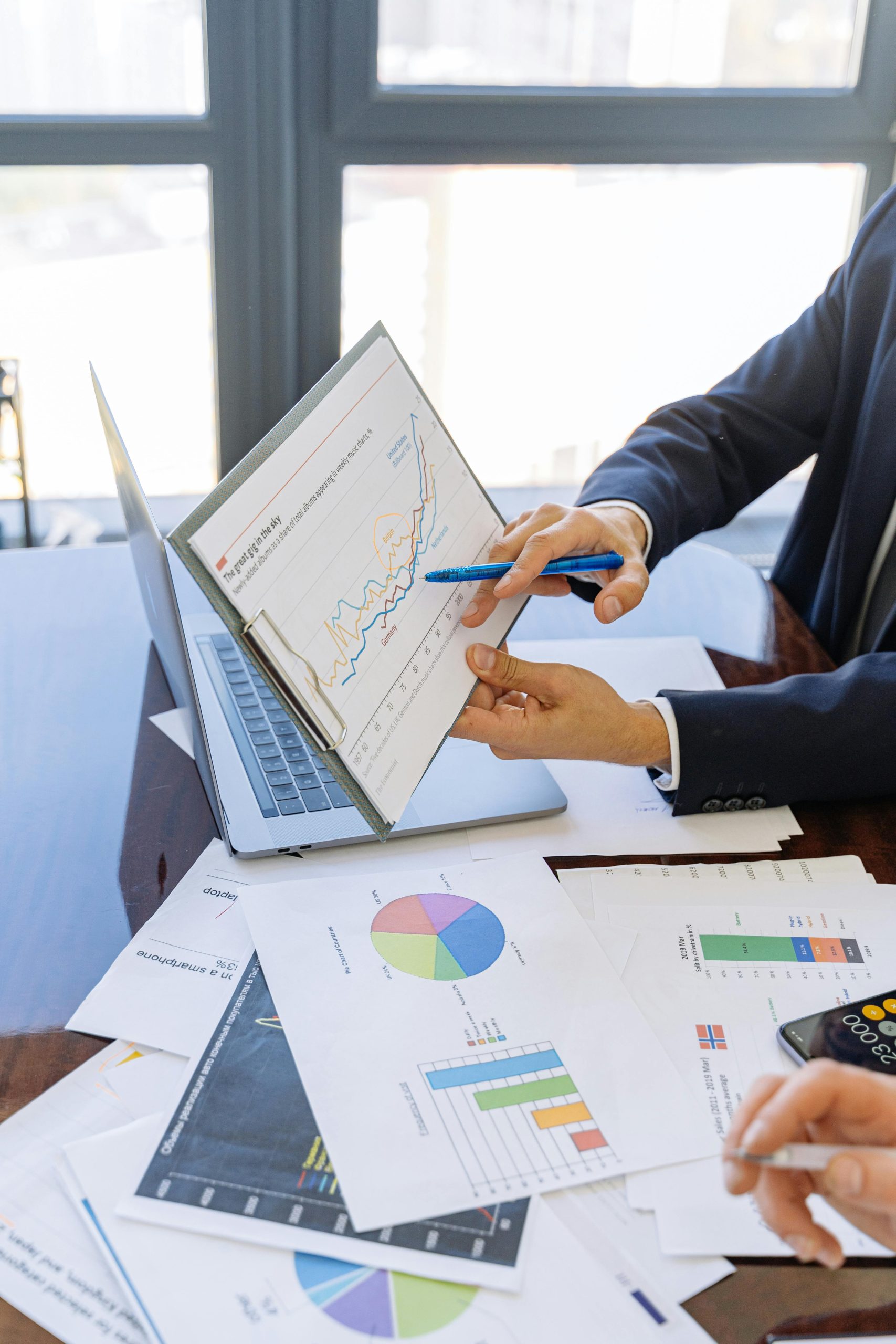 Inicio Business professionals discussing financial graphs and charts in an office setting.